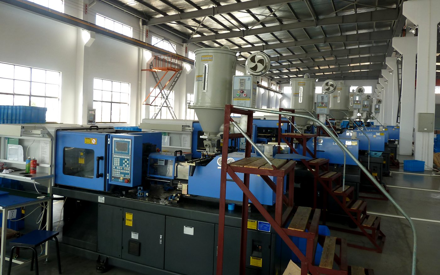 Injection molding machines with dryers and access stairs