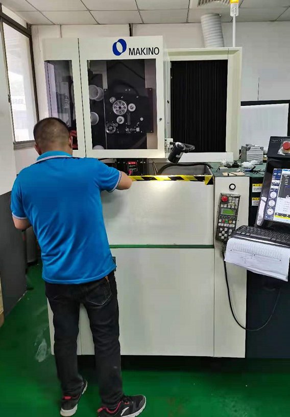 An operator at a Makino wire EDM machine